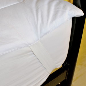 Strong elastic bands loop over the corners of your bed to keep your mattress topper in place